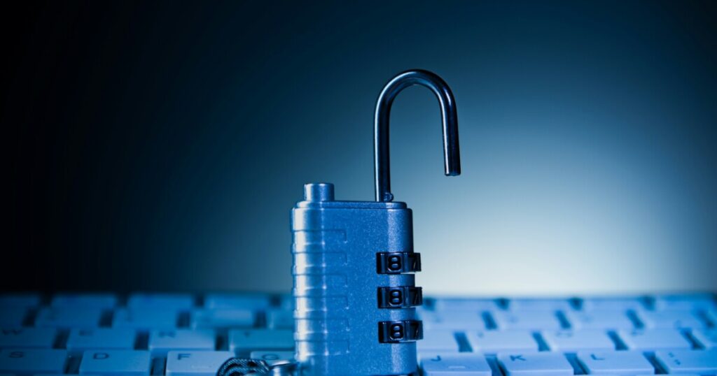 Open padlock resting on a computer keyboard, representing business cybersecurity